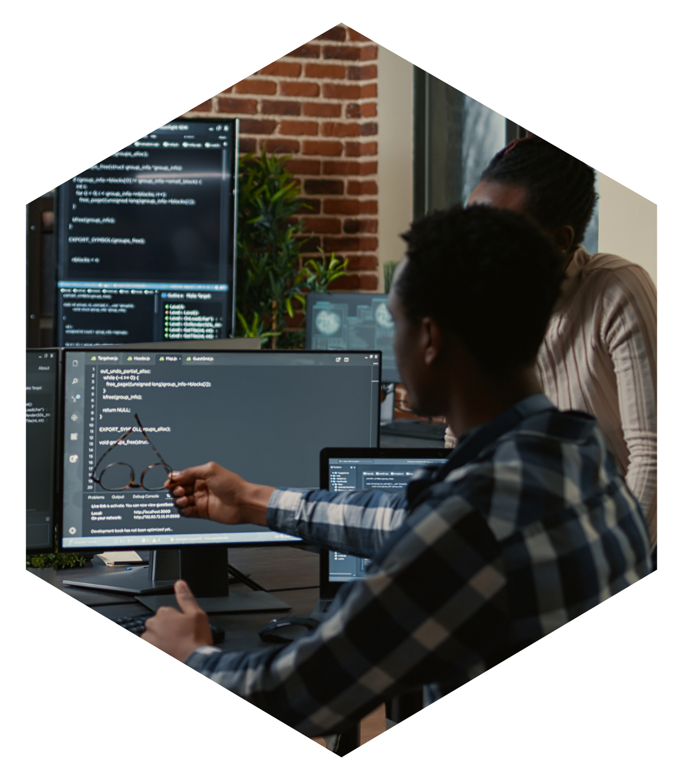 Man with co-workers, pointing at computer screen
